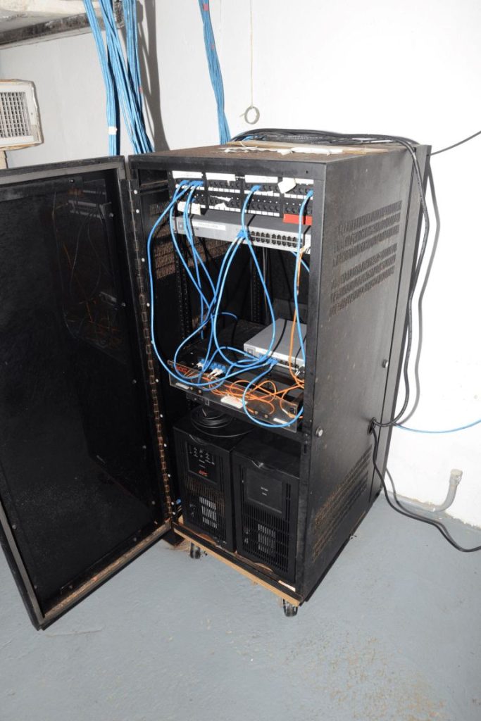 Rows of blue network cables connect servers inside a modern data centre room.